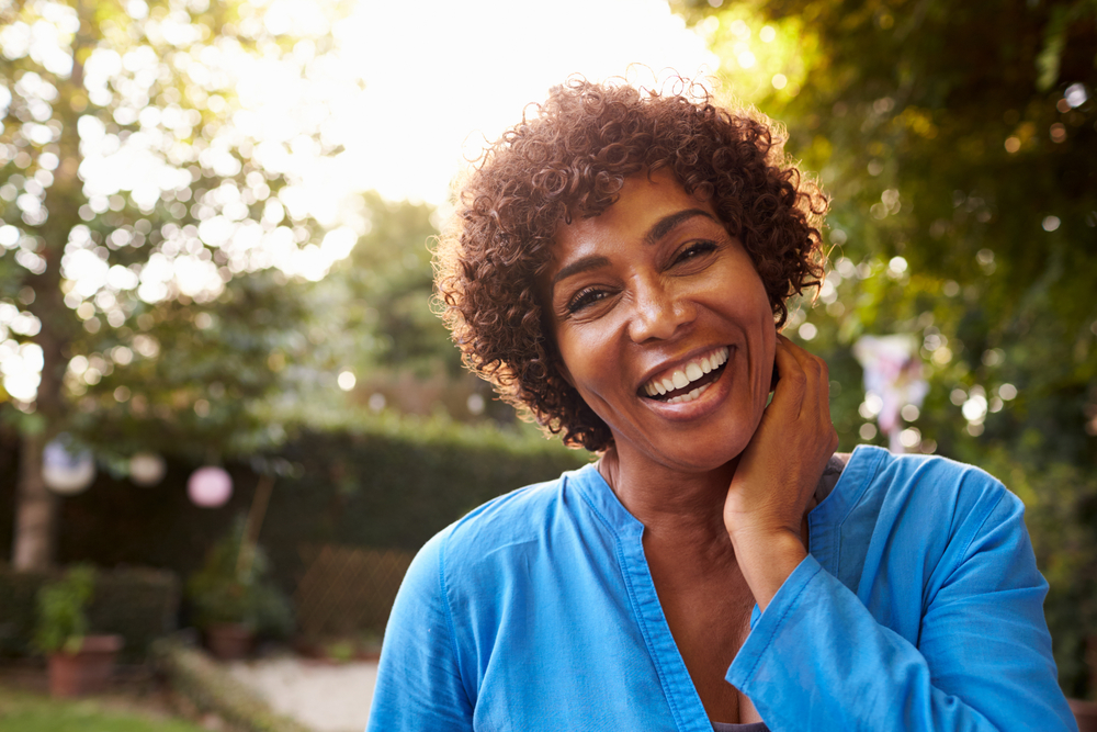 Smiling woman touching her neck