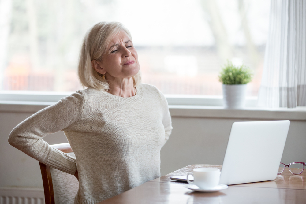 Woman sitting at a desk in pain